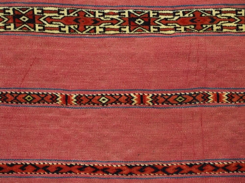 An antique rectangular Tekke Turkmen Kizil chuval woven textile with detailed horizontal geometric bands across a magenta red wool field. View VIII