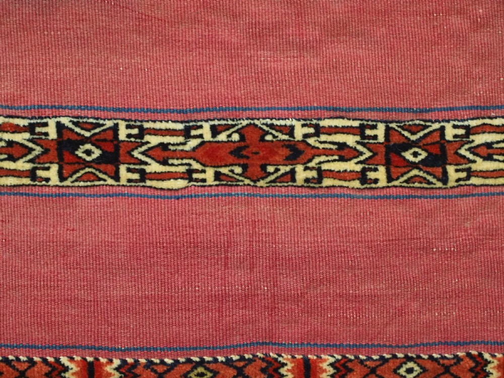 An antique rectangular Tekke Turkmen Kizil chuval woven textile with detailed horizontal geometric bands across a magenta red wool field. View XI