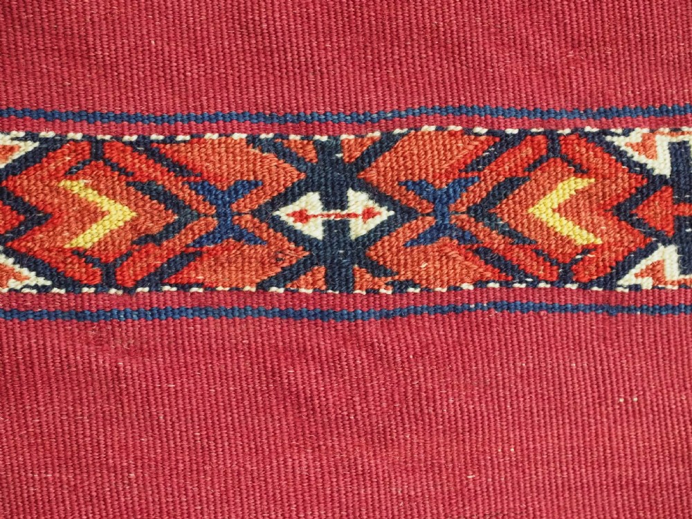 An antique rectangular Tekke Turkmen Kizil chuval woven textile with detailed horizontal geometric bands across a magenta red wool field. View XIII