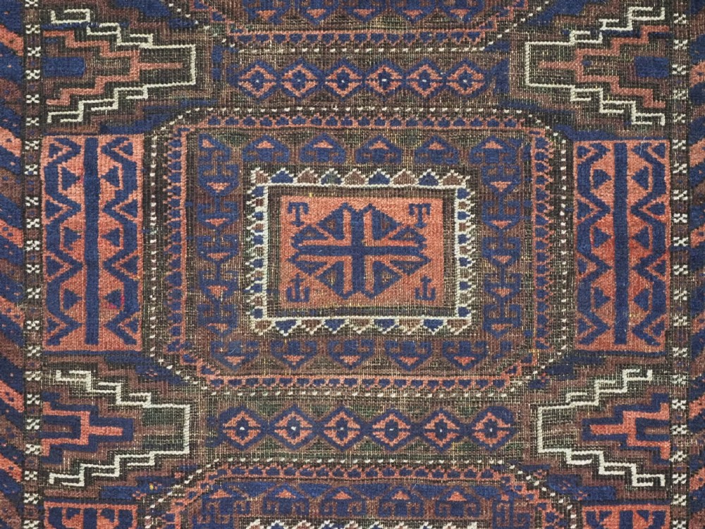An antique rectangular Baluch tribal rug featuring five central geometric box medallions in dark red and indigo blue against a patterned ground. View VIII