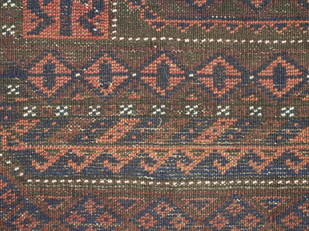 An antique rectangular Baluch tribal rug featuring five central geometric box medallions in dark red and indigo blue against a patterned ground. View XI