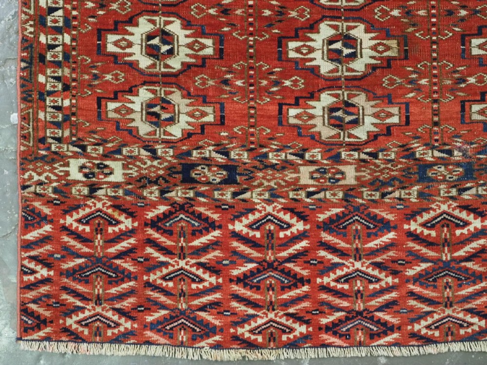 An antique hand-woven Tekke Turkmen chuval face featuring a grid of twenty-five repeating guls in deep red, navy blue, and ivory wool. View V