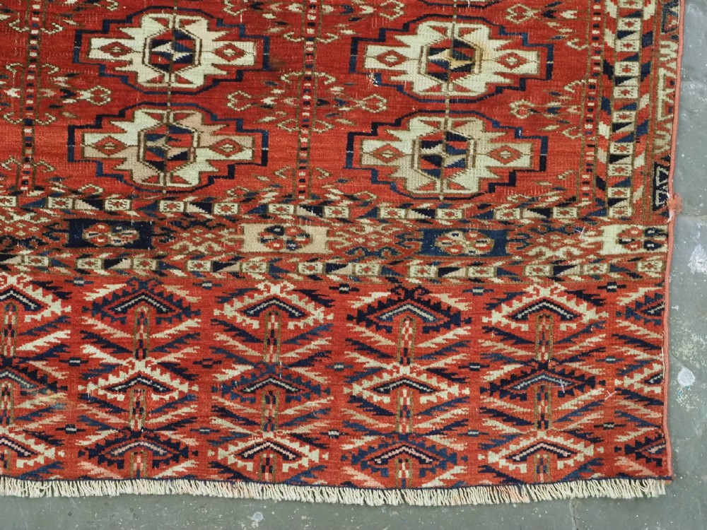 An antique hand-woven Tekke Turkmen chuval face featuring a grid of twenty-five repeating guls in deep red, navy blue, and ivory wool. View VII
