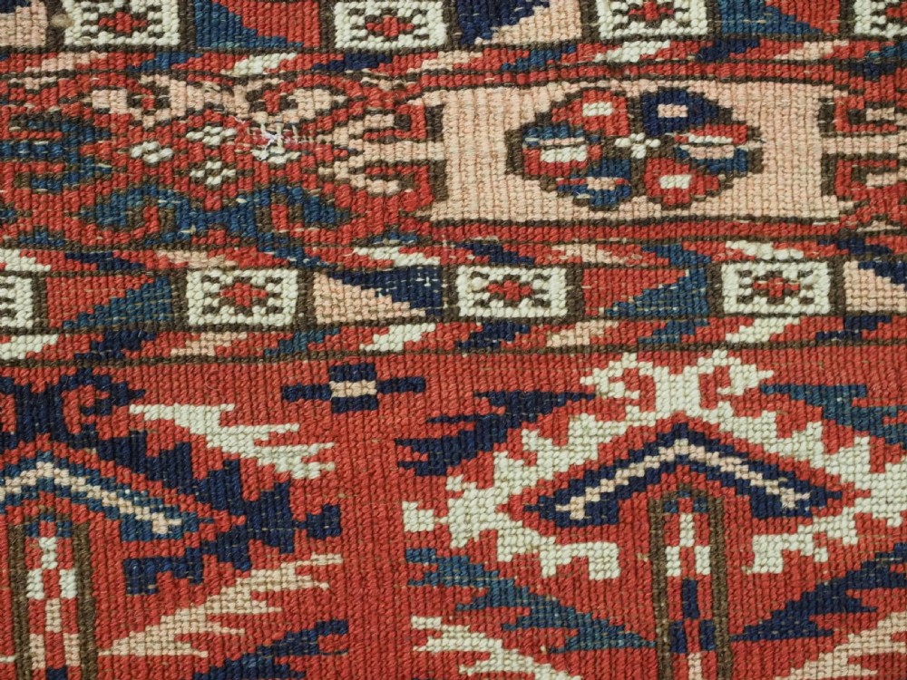 An antique hand-woven Tekke Turkmen chuval face featuring a grid of twenty-five repeating guls in deep red, navy blue, and ivory wool. View XII