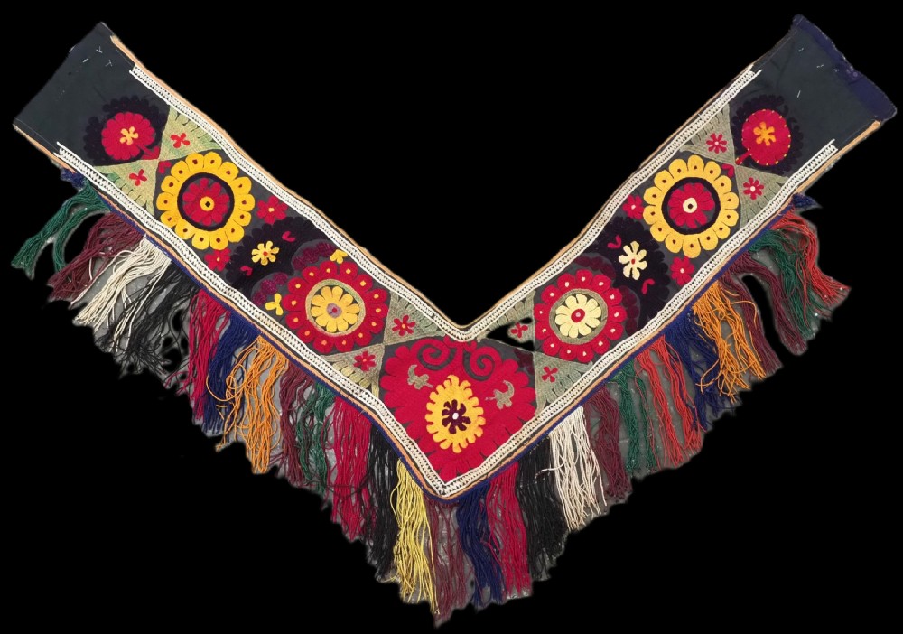 A V-shaped black cloth band decorated with vibrant red and yellow silk embroidered rosettes and finished with multi-coloured yarn fringe.