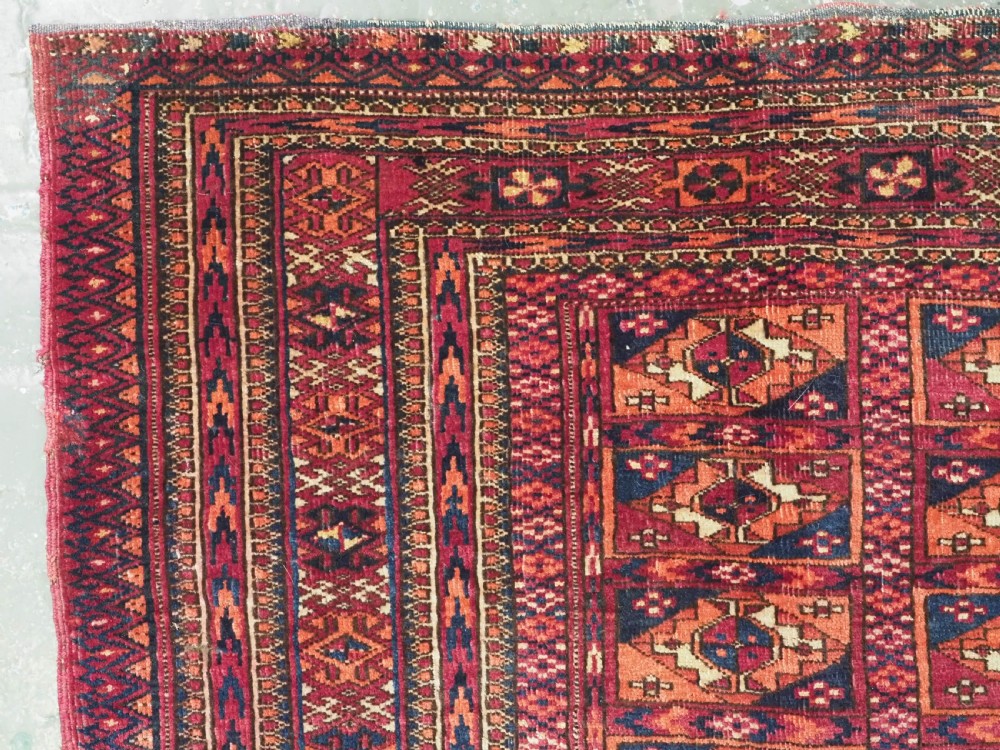 A rectangular late 19th-century Tekke Turkmen chuval face woven in madder red and navy wool featuring repeated geometric Aina gul motifs above a detailed floral elem skirt. View II