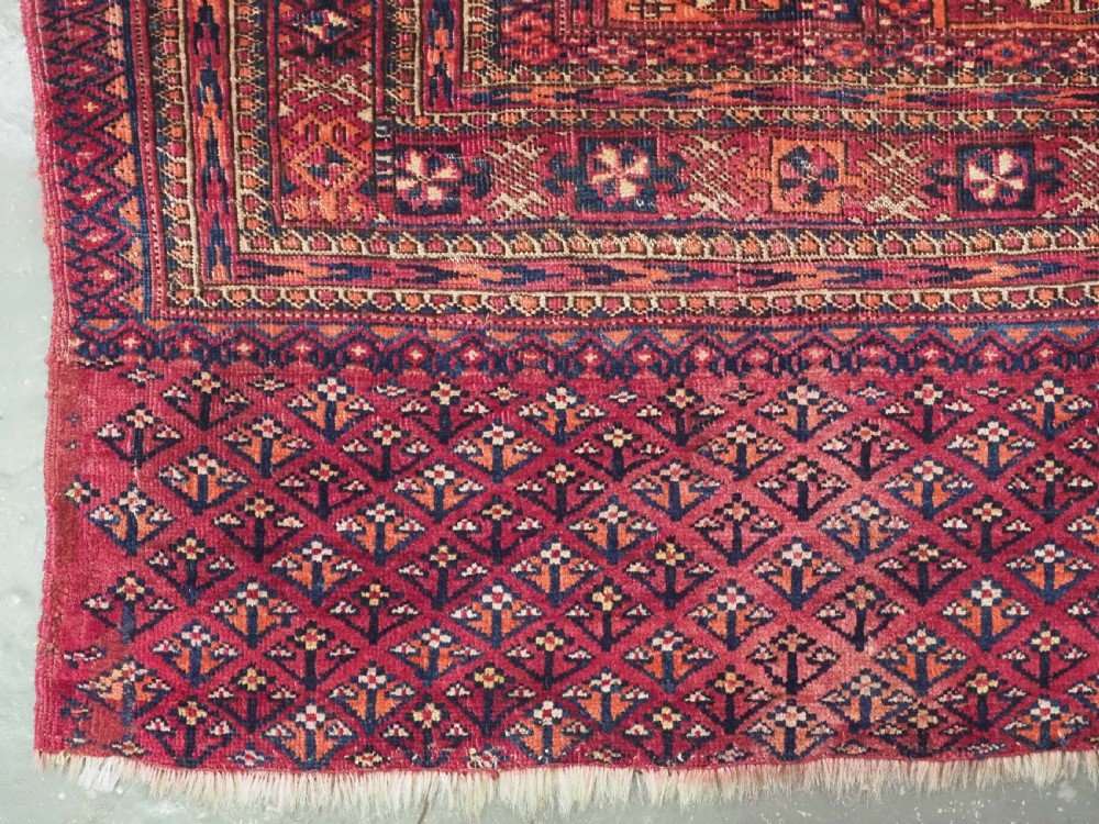 A rectangular late 19th-century Tekke Turkmen chuval face woven in madder red and navy wool featuring repeated geometric Aina gul motifs above a detailed floral elem skirt. View III