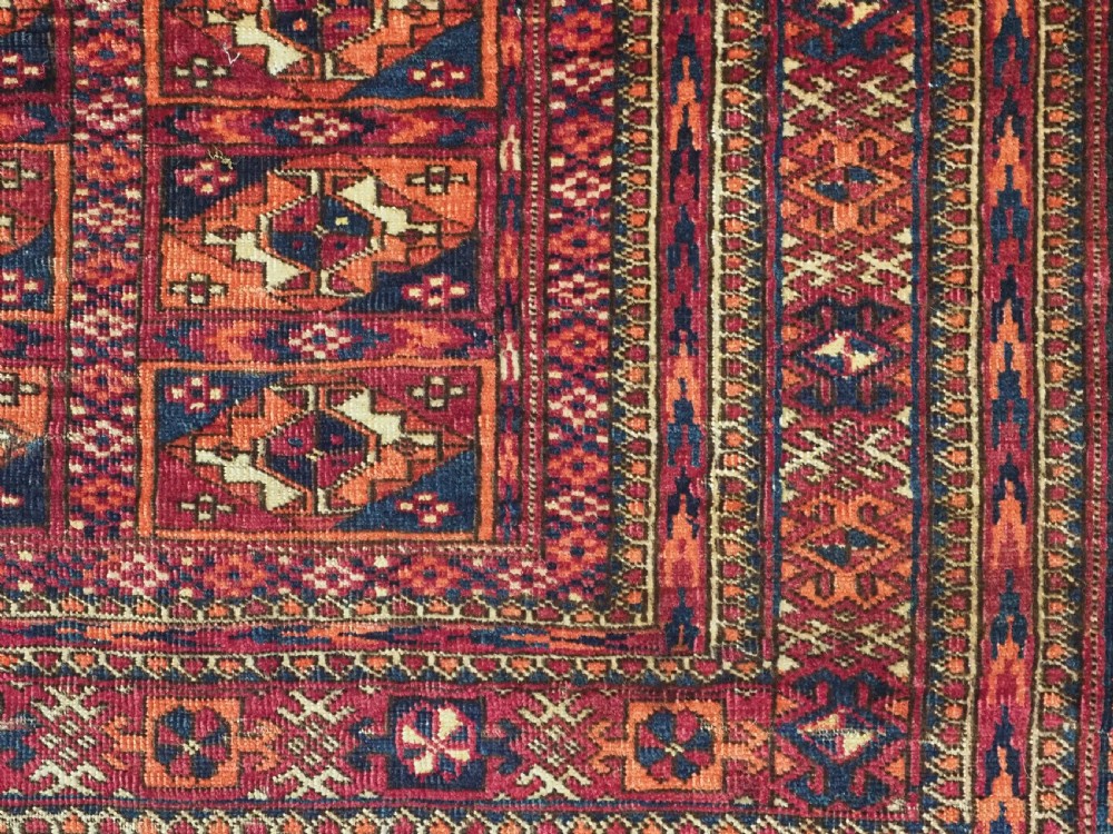 A rectangular late 19th-century Tekke Turkmen chuval face woven in madder red and navy wool featuring repeated geometric Aina gul motifs above a detailed floral elem skirt. View VIII