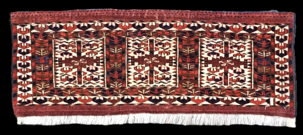 A horizontal handwoven Tekke Turkmen wool textile featuring three rectangular panels with tree designs bordered by intricate geometric patterns in red, navy, and ivory.