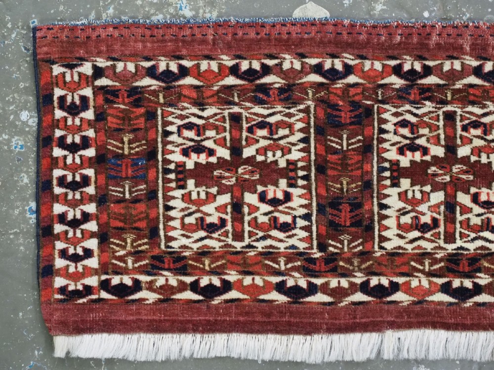 A horizontal handwoven Tekke Turkmen wool textile featuring three rectangular panels with tree designs bordered by intricate geometric patterns in red, navy, and ivory. View II