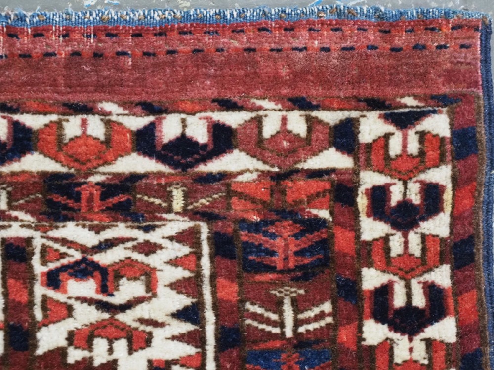 A horizontal handwoven Tekke Turkmen wool textile featuring three rectangular panels with tree designs bordered by intricate geometric patterns in red, navy, and ivory. View XI