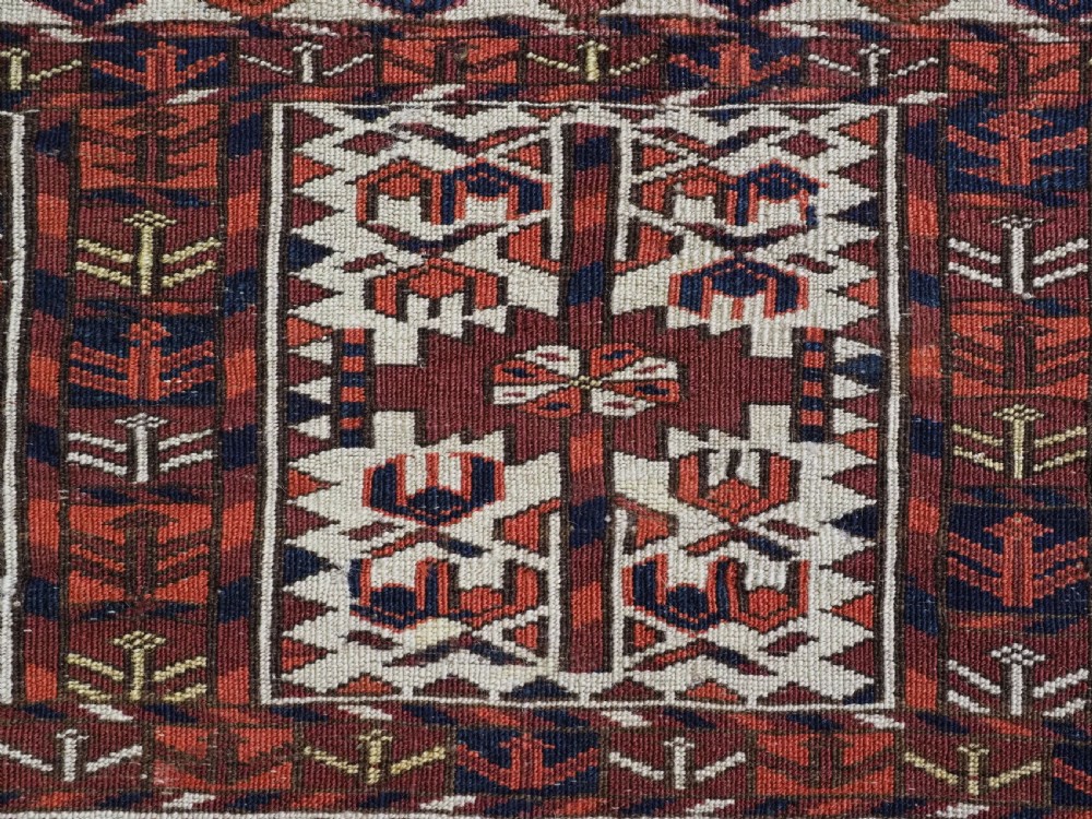 A horizontal handwoven Tekke Turkmen wool textile featuring three rectangular panels with tree designs bordered by intricate geometric patterns in red, navy, and ivory. View XIII