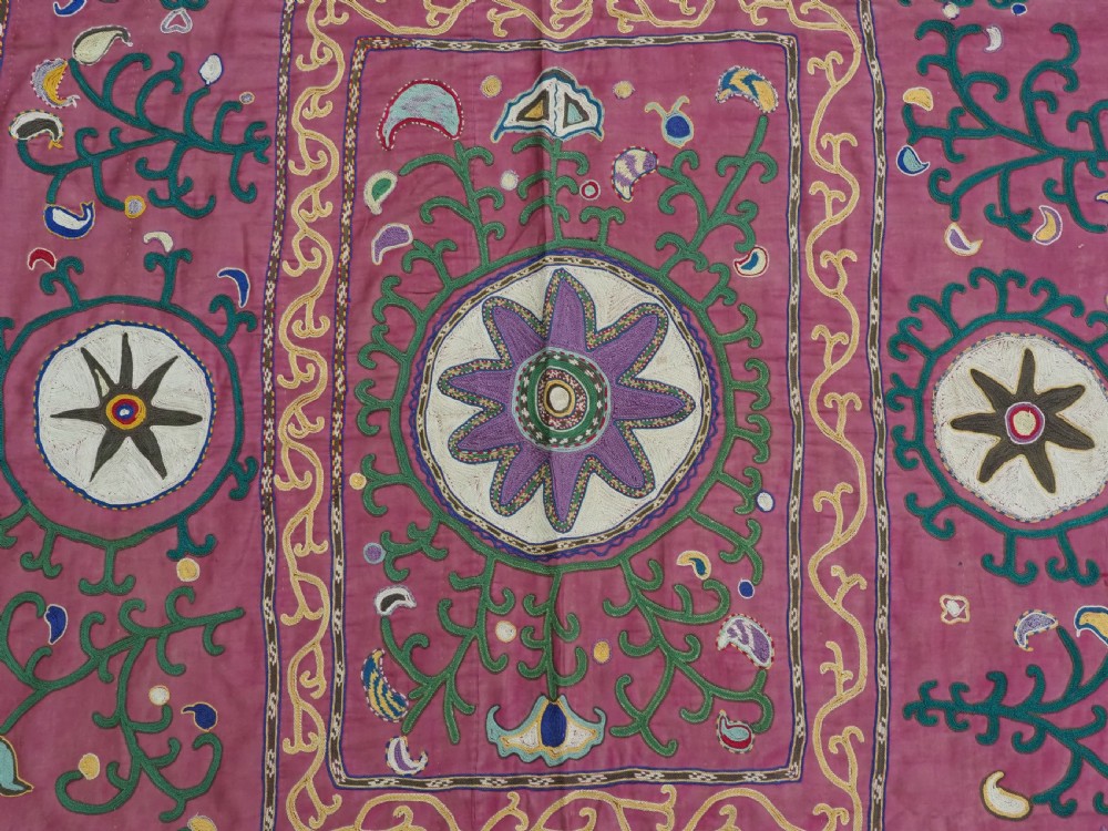 A rectangular hand-embroidered pink silk on cotton suzani textile featuring circular floral motifs, star shapes, and scrolling vine borders. View VII