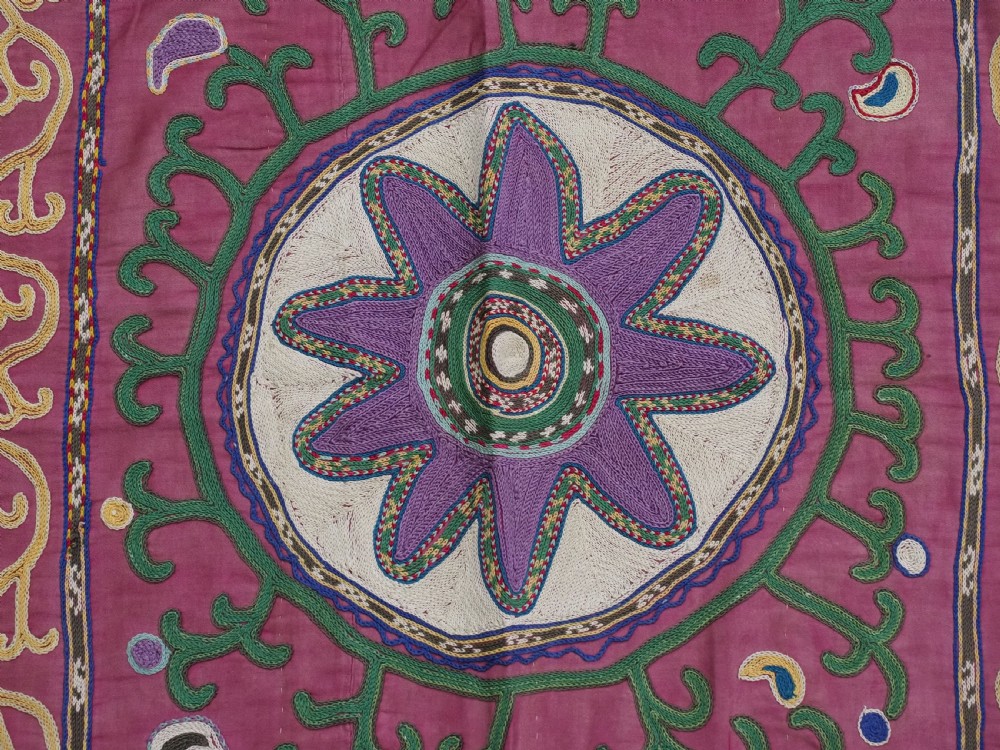 A rectangular hand-embroidered pink silk on cotton suzani textile featuring circular floral motifs, star shapes, and scrolling vine borders. View VIII