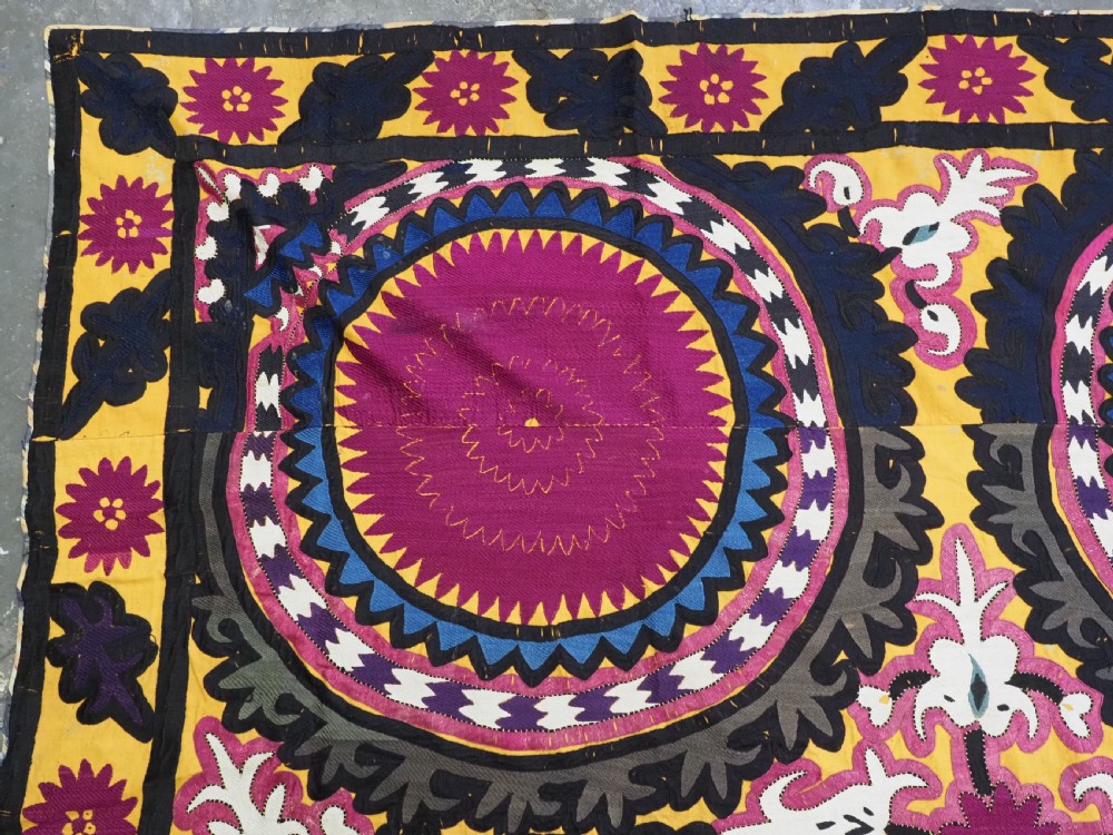 An antique Uzbek Samarkand suzani textile displaying nine large purple circular medallions framed by a yellow floral border. View III