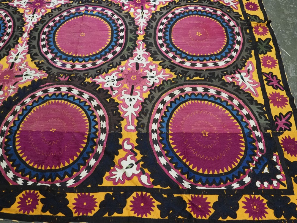 An antique Uzbek Samarkand suzani textile displaying nine large purple circular medallions framed by a yellow floral border. View VII