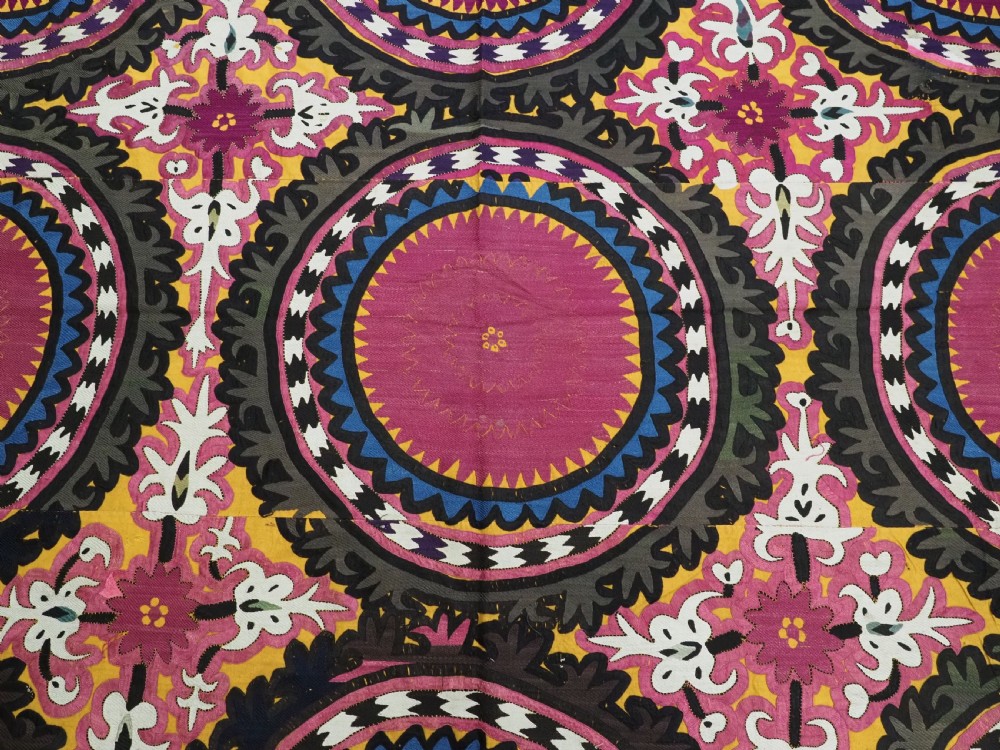 An antique Uzbek Samarkand suzani textile displaying nine large purple circular medallions framed by a yellow floral border. View VIII