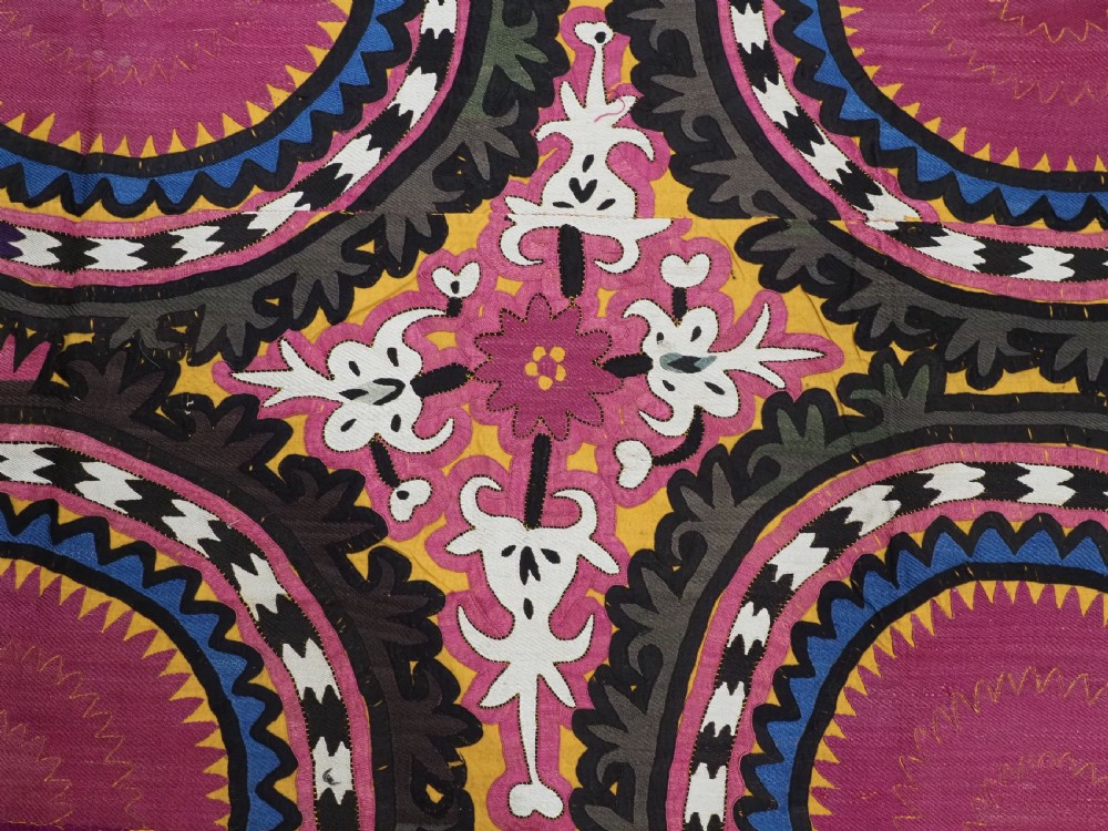 An antique Uzbek Samarkand suzani textile displaying nine large purple circular medallions framed by a yellow floral border. View X