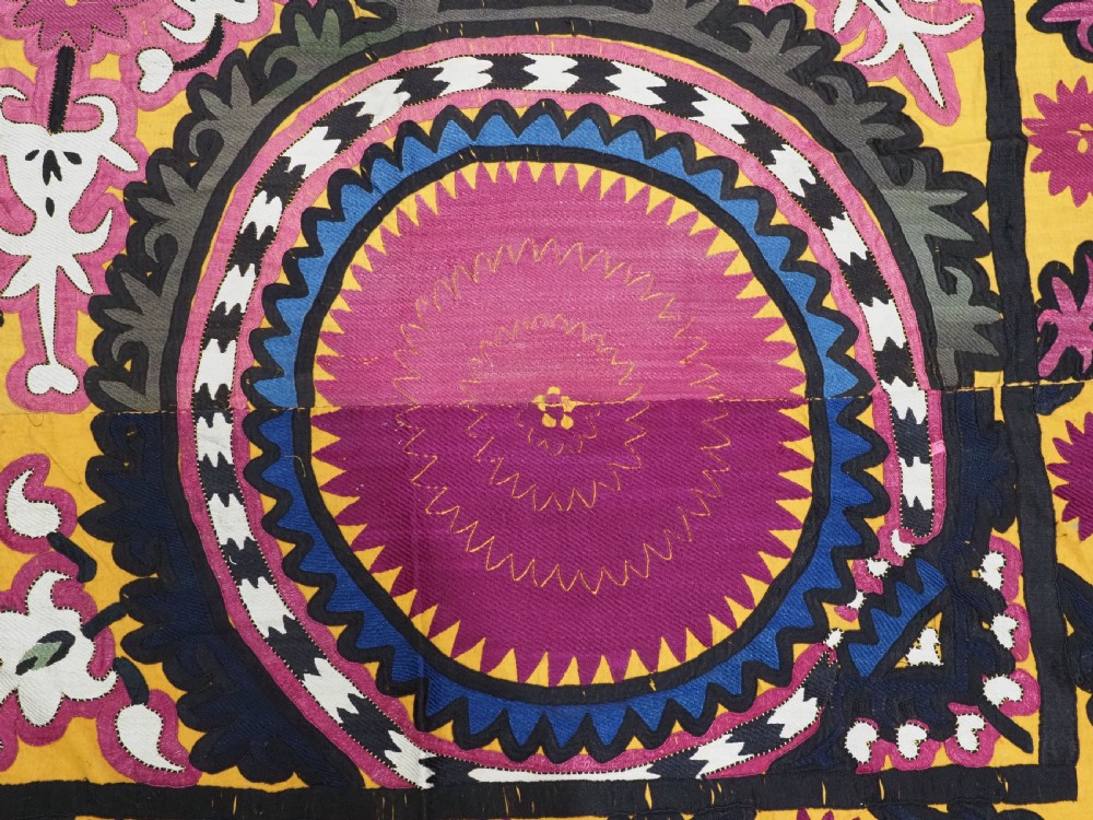 An antique Uzbek Samarkand suzani textile displaying nine large purple circular medallions framed by a yellow floral border. View XI