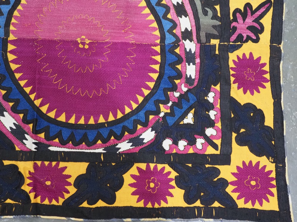 An antique Uzbek Samarkand suzani textile displaying nine large purple circular medallions framed by a yellow floral border. View XII