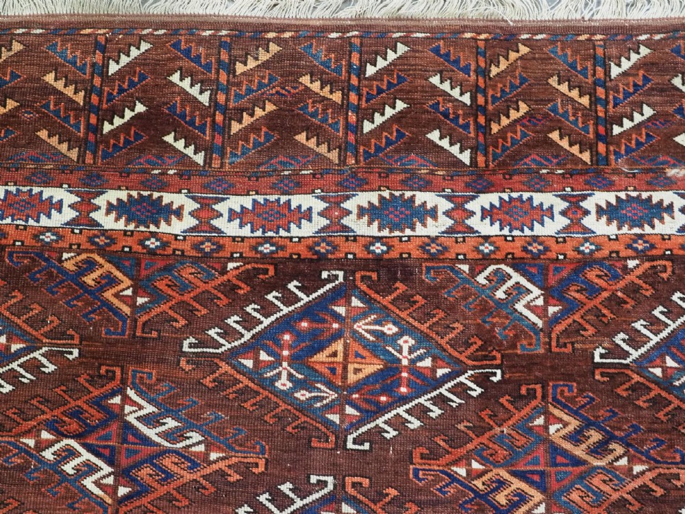 An antique Turkmen hand-knotted wool carpet featuring a repeating diamond dyrnak gul motif on a deep terracotta field with geometric borders. View VIII