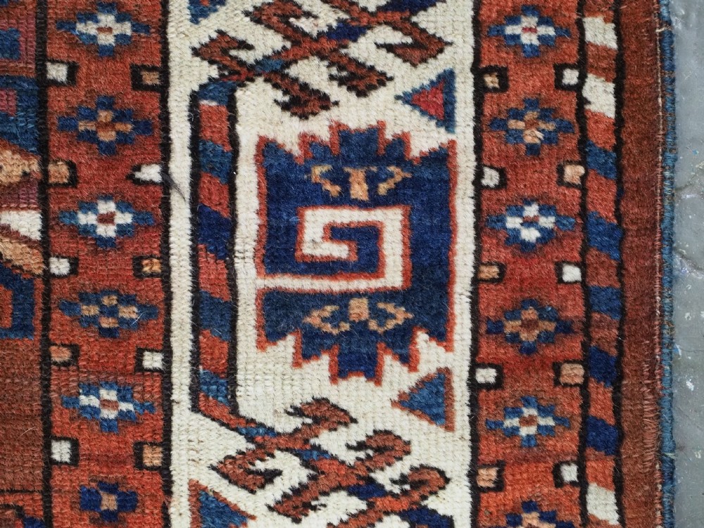 An antique Turkmen hand-knotted wool carpet featuring a repeating diamond dyrnak gul motif on a deep terracotta field with geometric borders. View XII