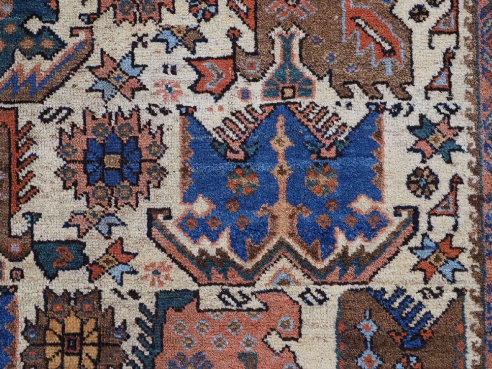 An antique hand-knotted Afshar wool rug featuring stylised dragon and phoenix motifs in blue, terracotta, and brown over an ivory ground within a geometric patterned border. View VIII