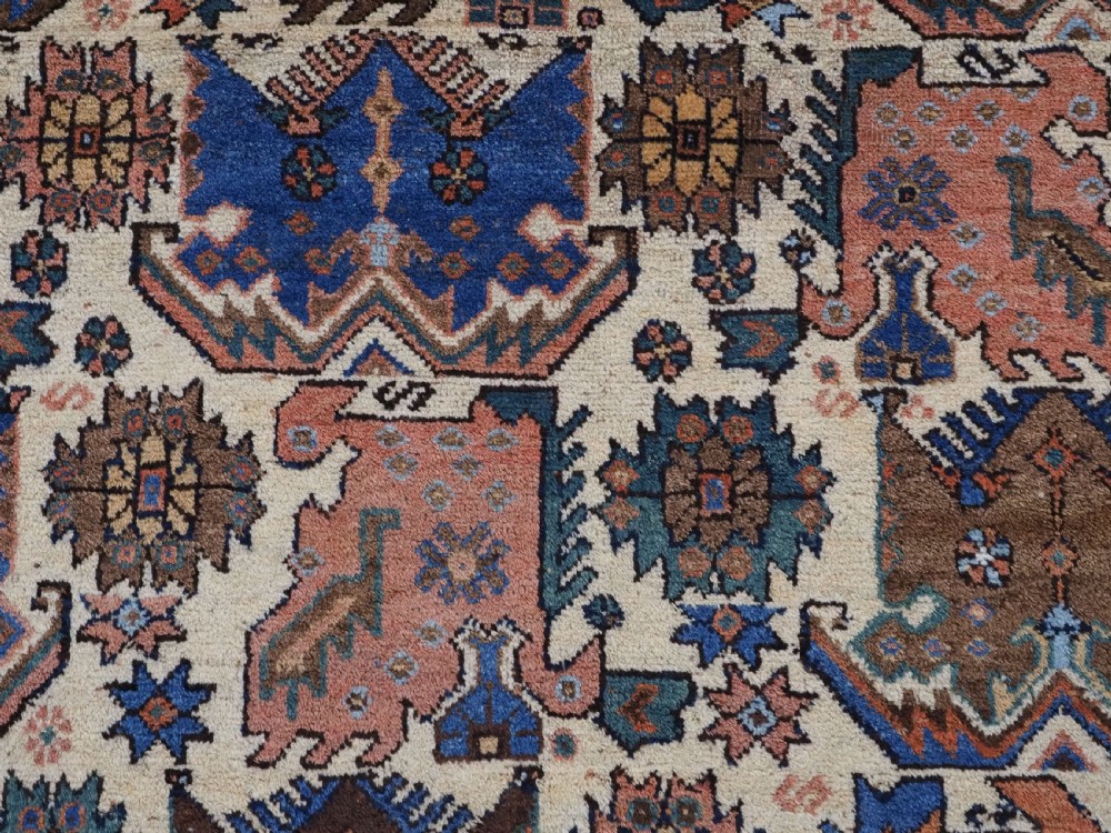An antique hand-knotted Afshar wool rug featuring stylised dragon and phoenix motifs in blue, terracotta, and brown over an ivory ground within a geometric patterned border. View IX