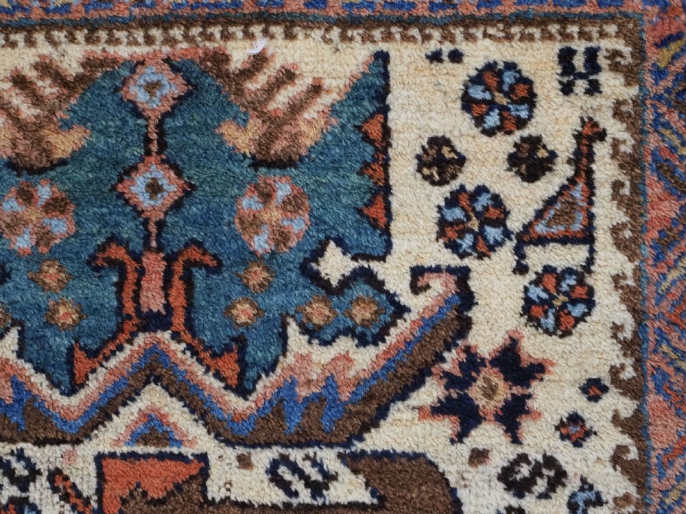 An antique hand-knotted Afshar wool rug featuring stylised dragon and phoenix motifs in blue, terracotta, and brown over an ivory ground within a geometric patterned border. View XII