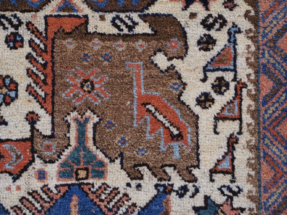 An antique hand-knotted Afshar wool rug featuring stylised dragon and phoenix motifs in blue, terracotta, and brown over an ivory ground within a geometric patterned border. View XIII