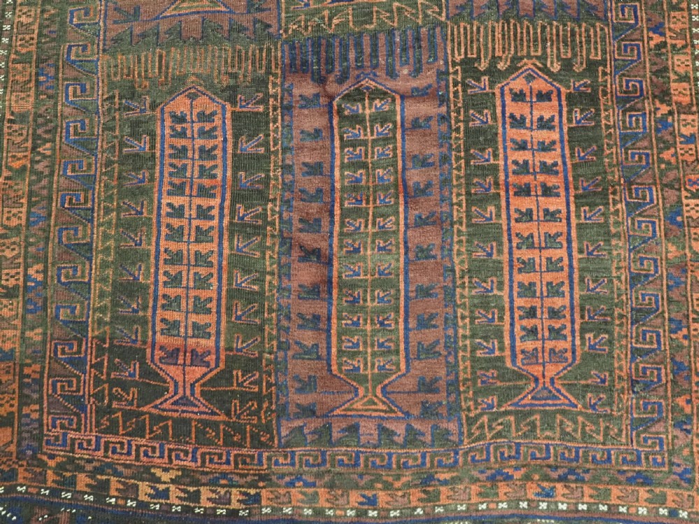 A late nineteenth-century hand-knotted wool Baluch carpet featuring repeated geometric column motifs in indigo, dark red, and purple shades within multiple patterned borders. View XI