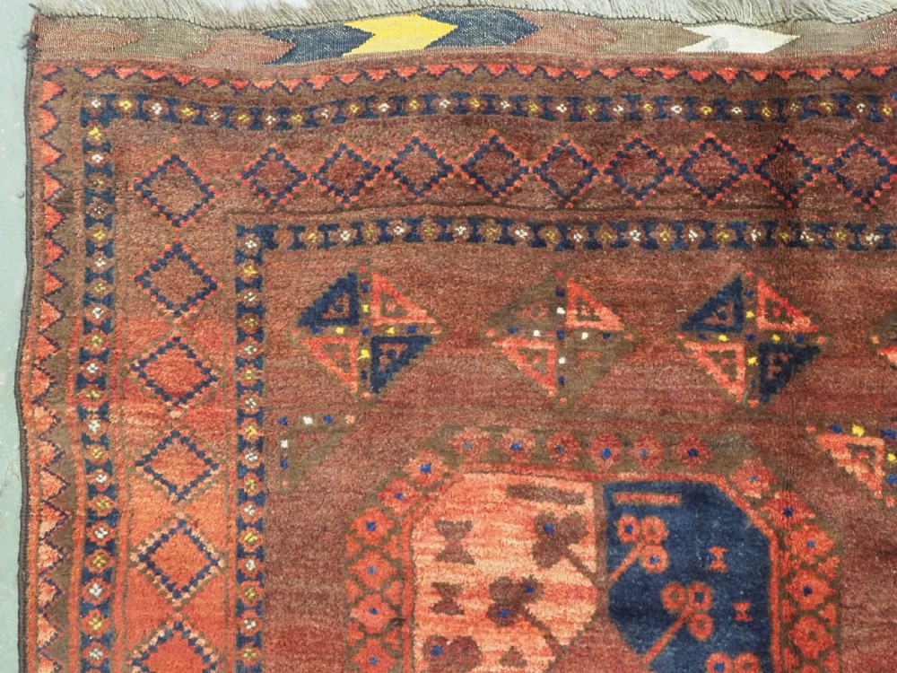 An antique hand-knotted Ersari Turkmen wool carpet featuring repeating octagonal gul medallions on a deep red field with geometric borders. View VI
