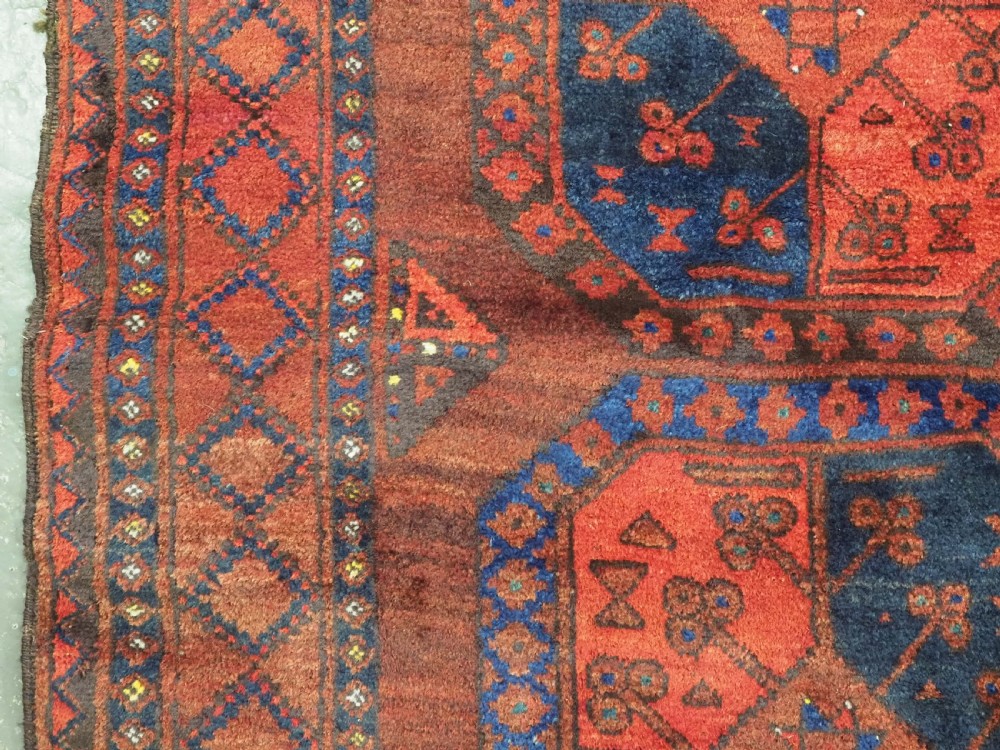 An antique hand-knotted Ersari Turkmen wool carpet featuring repeating octagonal gul medallions on a deep red field with geometric borders. View VII