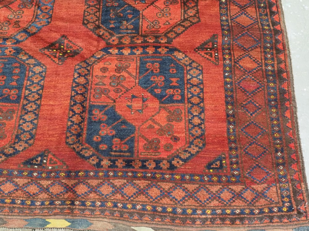 An antique hand-knotted Ersari Turkmen wool carpet featuring repeating octagonal gul medallions on a deep red field with geometric borders. View XI