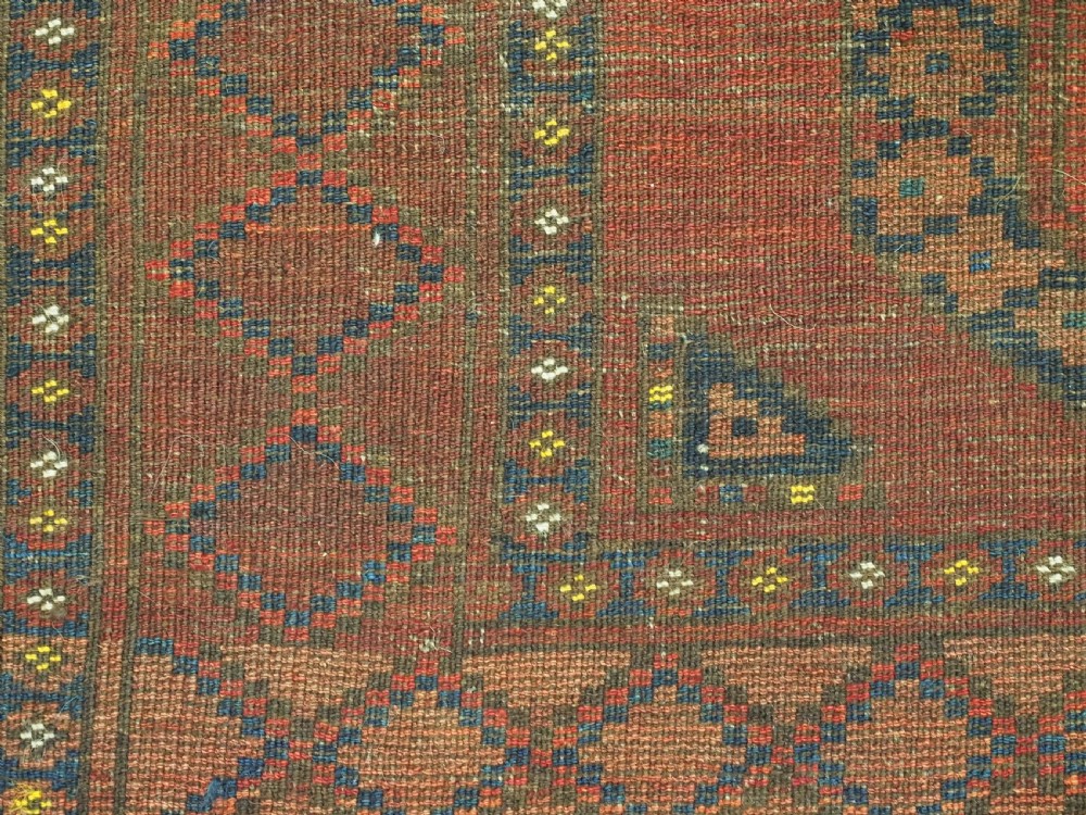 An antique hand-knotted Ersari Turkmen wool carpet featuring repeating octagonal gul medallions on a deep red field with geometric borders. View XIII