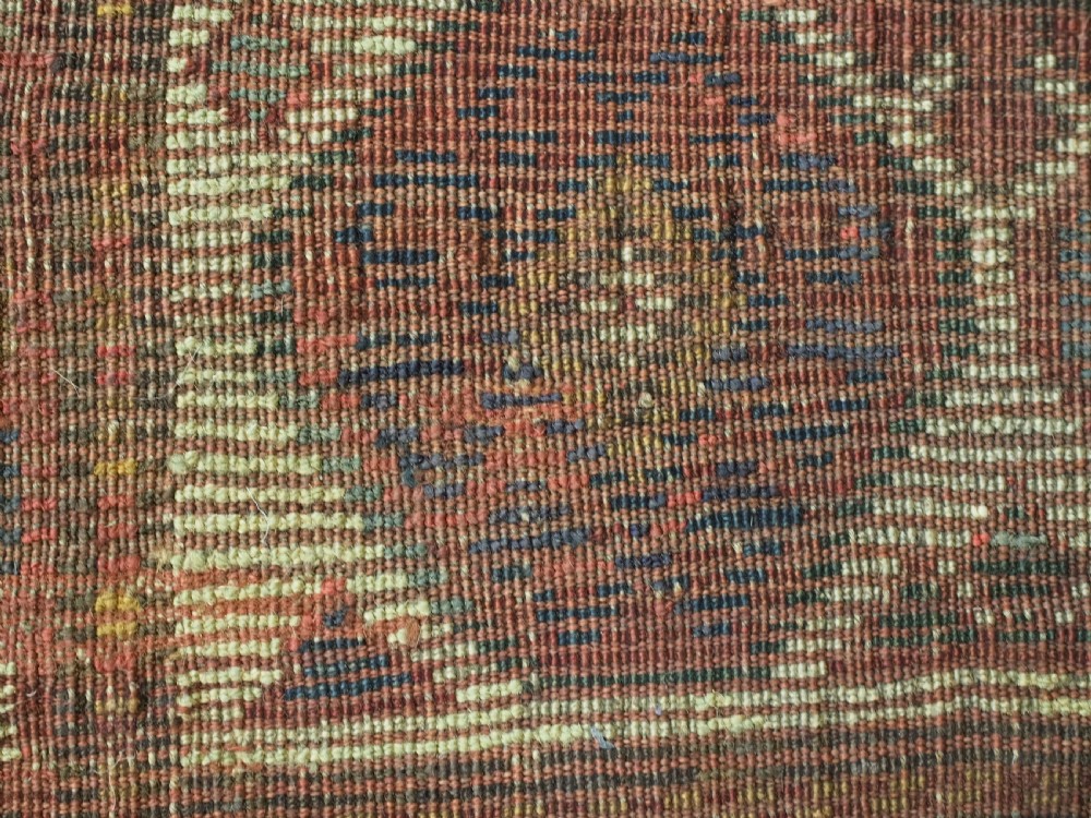 An antique hand-knotted Caucasian Moghan Kazak wool rug featuring a grid of geometric latch-hook medallions framed by patterned borders. View XII