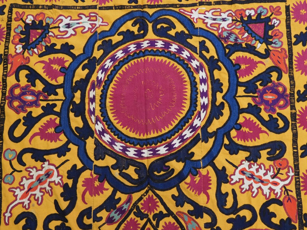 An antique Uzbek prayer suzani featuring silk embroidery with circular floral medallions and a central arch motif on a yellow cotton ground. View VI