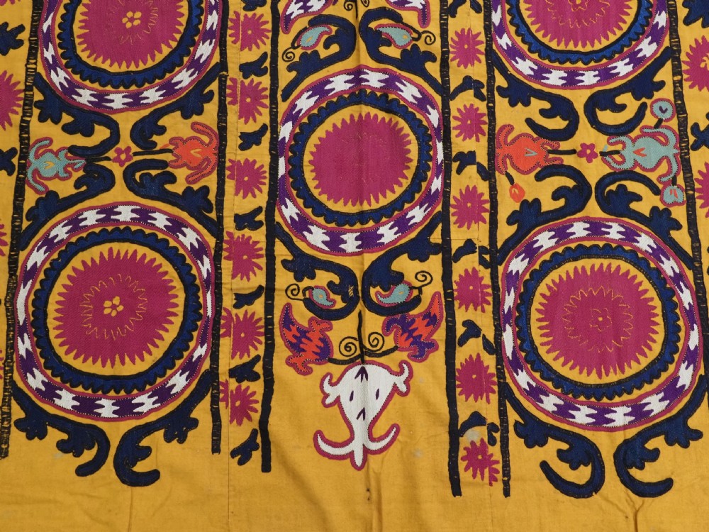 An antique Uzbek prayer suzani featuring silk embroidery with circular floral medallions and a central arch motif on a yellow cotton ground. View VIII