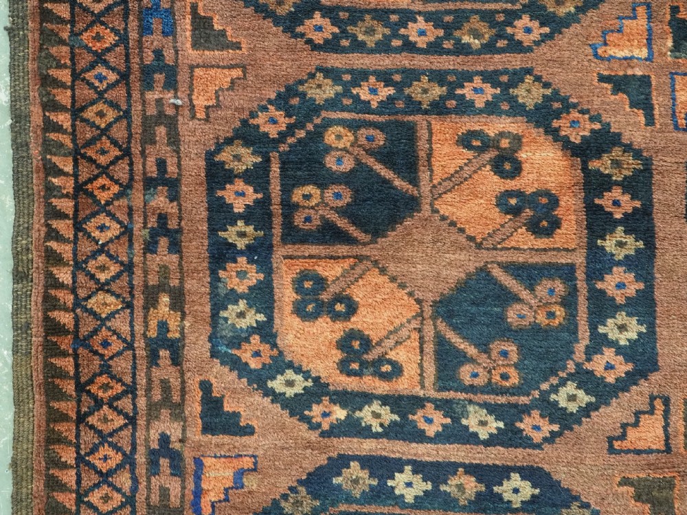 An antique hand-knotted Ersari Turkmen wool carpet featuring a repeated octagonal gul pattern in terracotta red, navy blue, and brown shades. View VII
