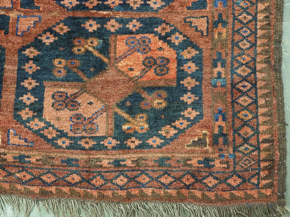 An antique hand-knotted Ersari Turkmen wool carpet featuring a repeated octagonal gul pattern in terracotta red, navy blue, and brown shades. View XI