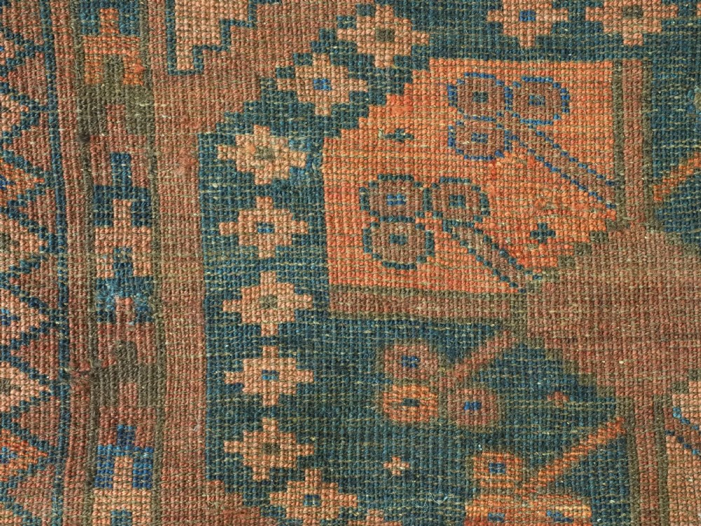 An antique hand-knotted Ersari Turkmen wool carpet featuring a repeated octagonal gul pattern in terracotta red, navy blue, and brown shades. View XII