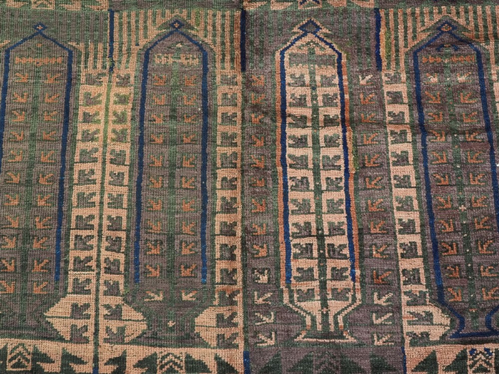 An antique hand-knotted wool carpet featuring a repeating kalam donneh pencil box pattern in shades of terracotta, dark brown, and indigo blue. View X