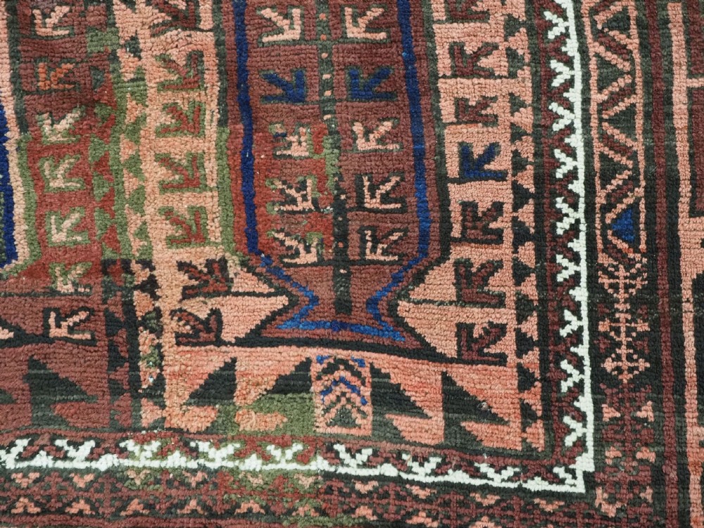 An antique hand-knotted wool carpet featuring a repeating kalam donneh pencil box pattern in shades of terracotta, dark brown, and indigo blue. View XIV