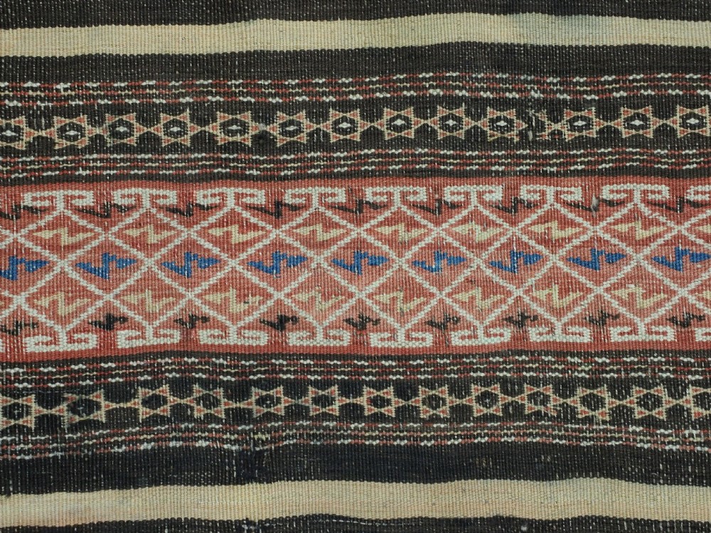An antique handwoven Afghan Baluch kilim rug featuring horizontal geometric bands in red, blue, cream, and dark brown wool. View IX