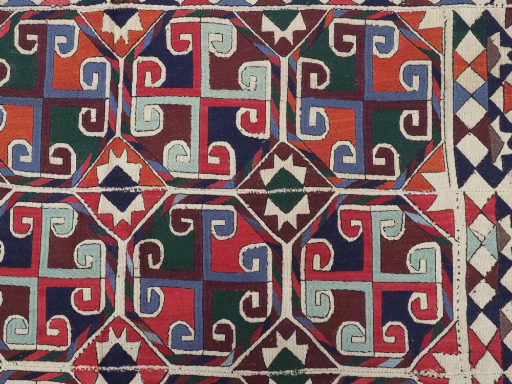 A rectangular antique Uzbek flatweave textile featuring repeating geometric octagonal medallions in red, green, blue, and cream with detailed motif borders. View VIII