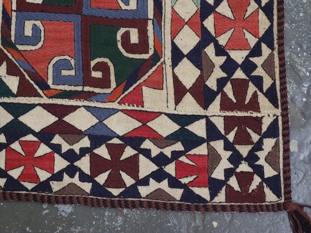 A rectangular antique Uzbek flatweave textile featuring repeating geometric octagonal medallions in red, green, blue, and cream with detailed motif borders. View XI
