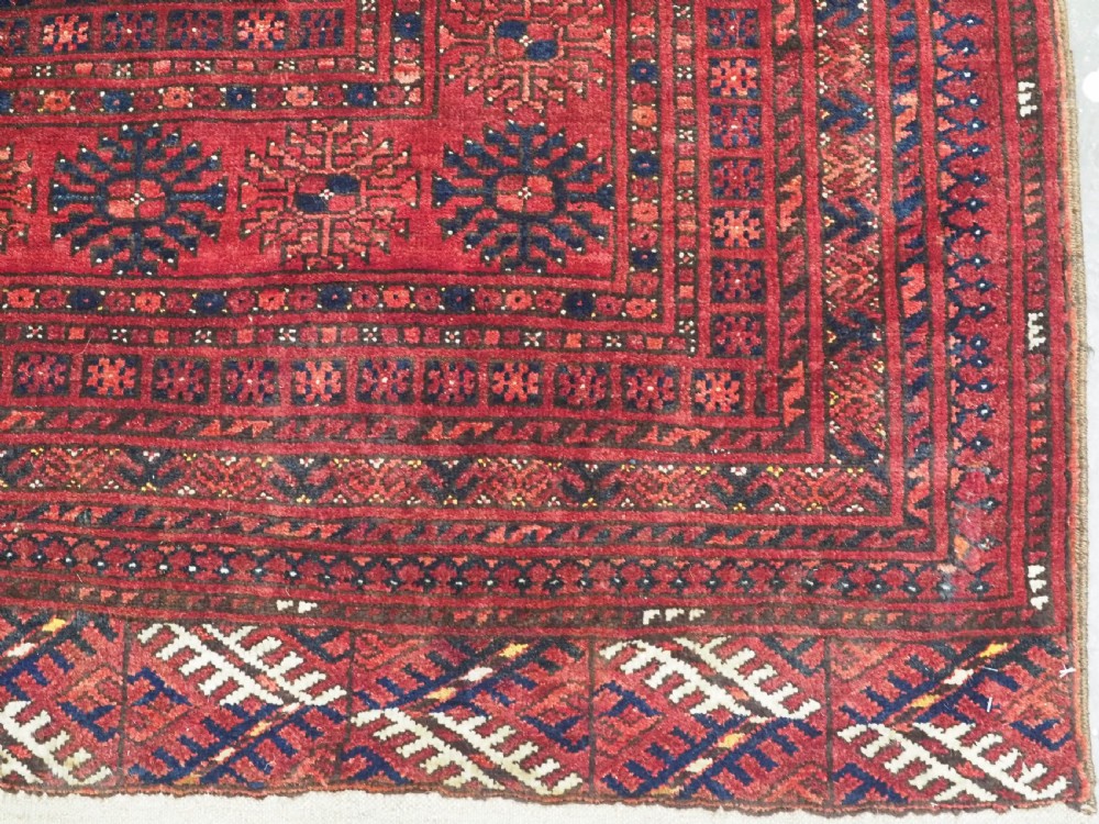 A large hand-knotted red wool carpet featuring repeated octagonal gul motifs across the central field with geometric borders. View XVIII