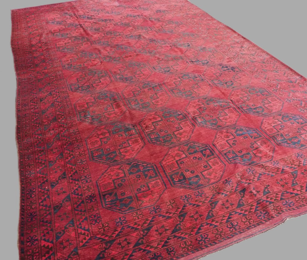 A large antique hand-knotted Afghan Ersari wool carpet featuring repeating octagonal gul patterns on a deep red field. View II