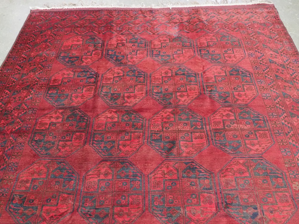 A large antique hand-knotted Afghan Ersari wool carpet featuring repeating octagonal gul patterns on a deep red field. View III