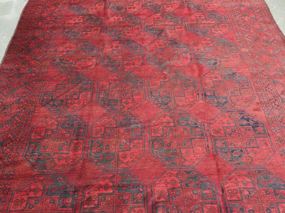 A large antique hand-knotted Afghan Ersari wool carpet featuring repeating octagonal gul patterns on a deep red field. View IV